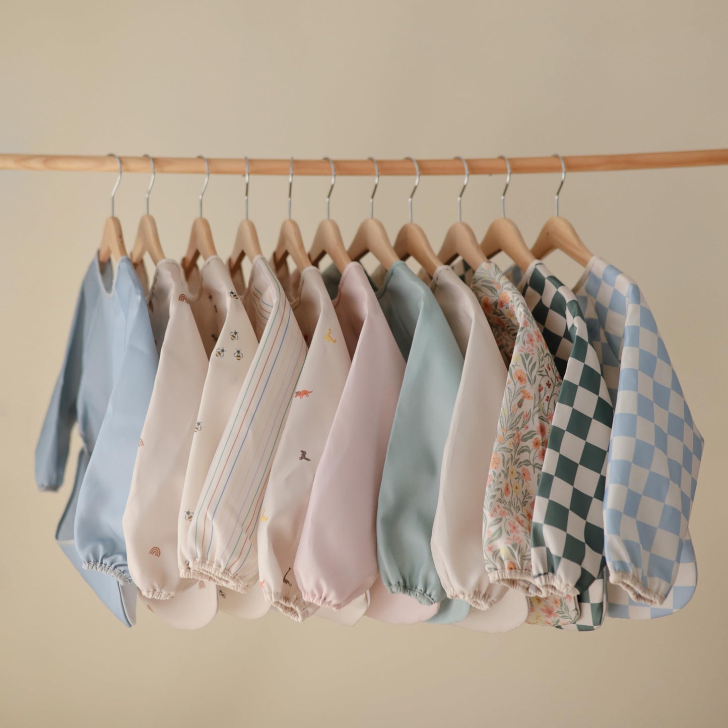 mushie Long Sleeve Baby Bib | Water Resistant Adjustable Fit for Ages 6-24 Months (Pastel Blooms)